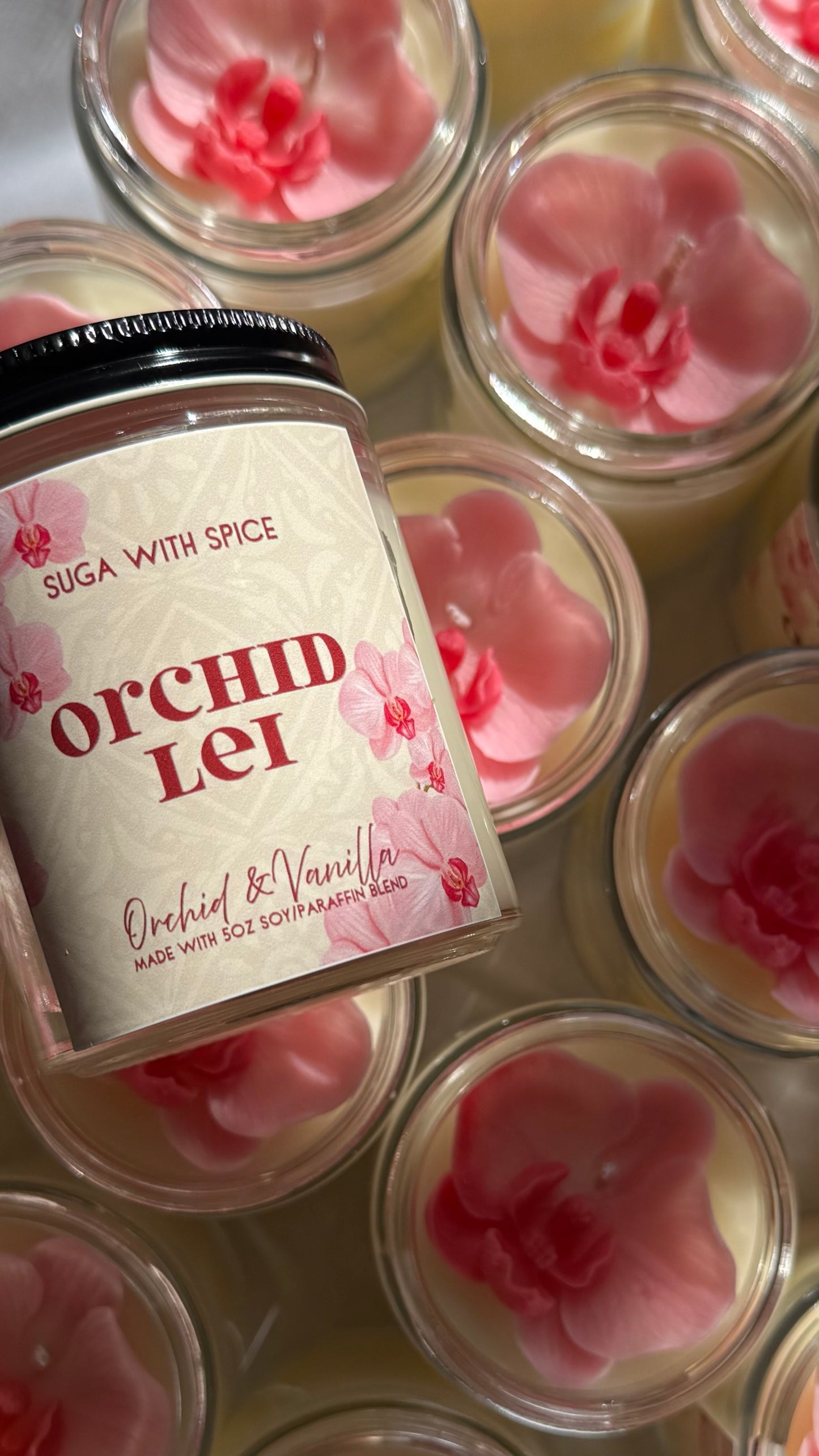 Jar of 'Orchid Lei' with pink flower-shaped candles on a white background